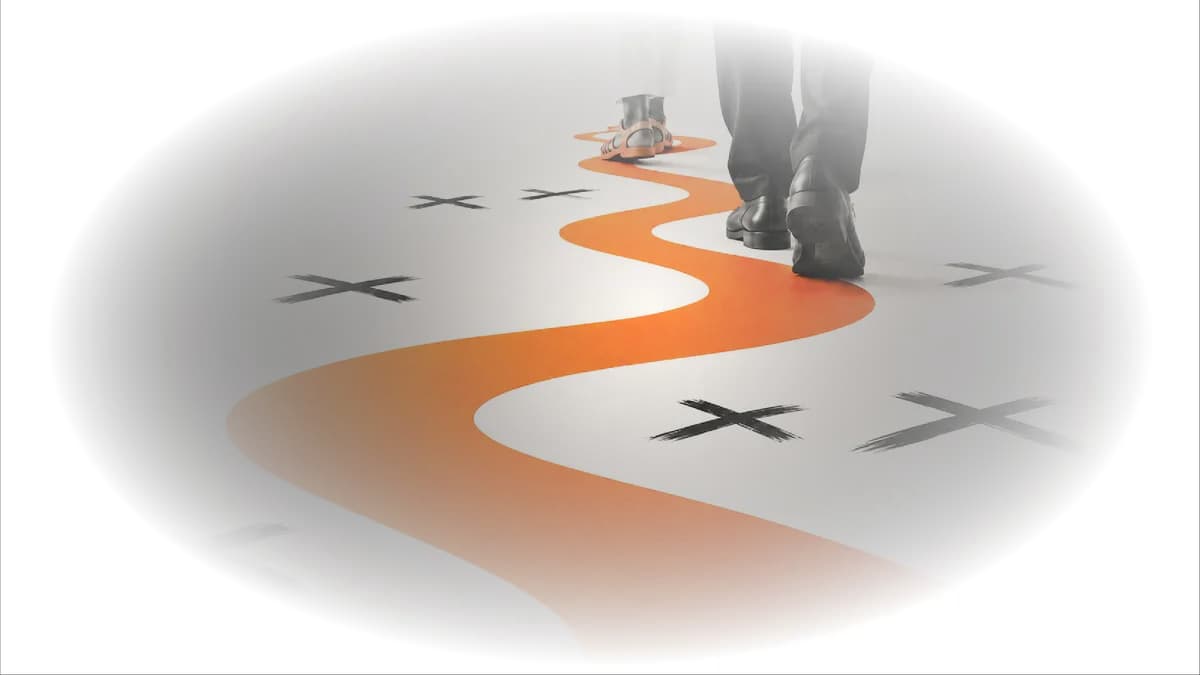 An orange path winding across a floor strewn with crosses